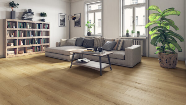 Albendo, vloeren specialist - Moderne woonkamer met Plak PVC Summerfield Sand - Dryback LV6703P vloerbedekking, een grijs bankstel met kussens, salontafel, boekenkast, muurkunst, grote ramen en een hoge potplant in de hoek.