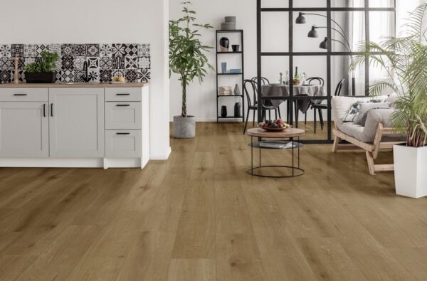 Albendo, vloeren specialist - Moderne open leefruimte met Click PVC 5100 (harde klik) Natural Oak Dark vloeren, grijze keukenkasten, een eethoek met zwarte tafel en stoelen, een gezellige leefzone en verschillende groene planten.