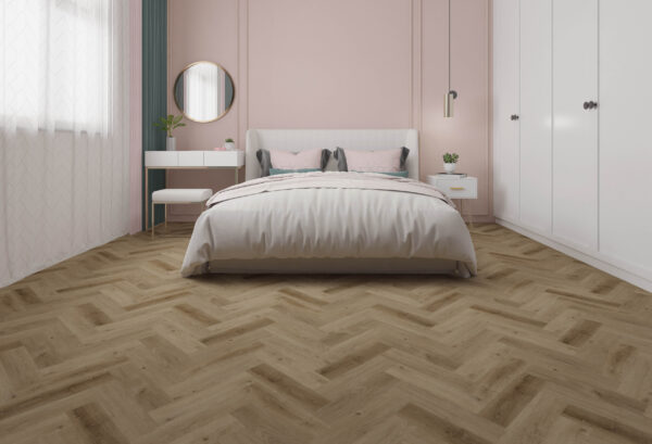 Albendo, vloeren specialist - Een moderne slaapkamer met een Click PVC Visgraat 5401 (Rigid Click) Prestige Oak Smoked visgraatvloer, een wit bed met grijze en roze kussens, een ronde spiegel boven een wit bureau, pastelroze muren, witte kledingkasten en natuurlijk licht vanuit het raam.